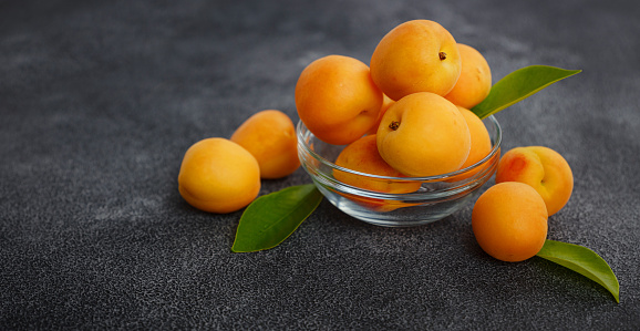 Delicious ripe Fresh juicy apricots on black background, close-up. Selection of healthy vegetarian food, detox or diet concept.