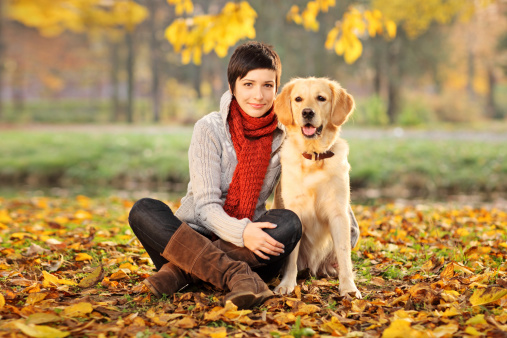 A beautiful woman and his dog (Labrador retriever) posing outside