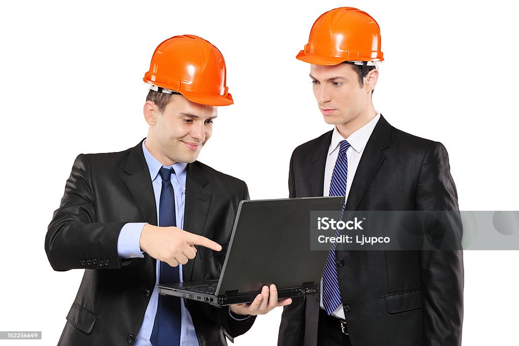 Two foremen looking at laptop Two foremen looking at laptop isolated on white background Adult Stock Photo