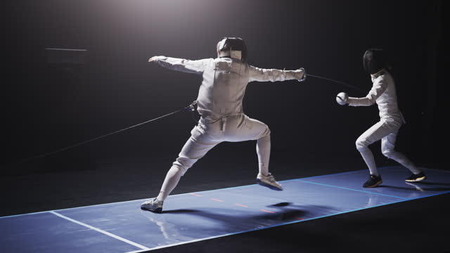 Rear view two professional fencers clashing in combat. Lunging forward and precise hit on the arm