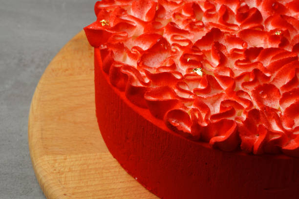 Stock photo shows a deliciously sliced red velvet cake with creamy cheese icing and perfectly layered sections, decorated with romantic love hearts, ideal for celebrating Valentine's Day. The rich, moist texture of the cake paired with the sweet, smooth icing makes it a perfect dessert for the occasion