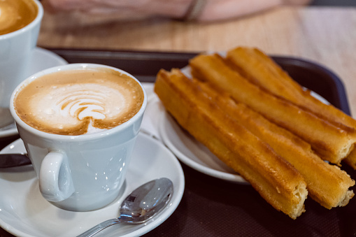 Close-up, traditional Spanish breakfast, latte and churros.