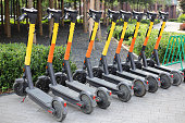 Electric scooters for public share standing outside on the city street. Public mobile transportation.