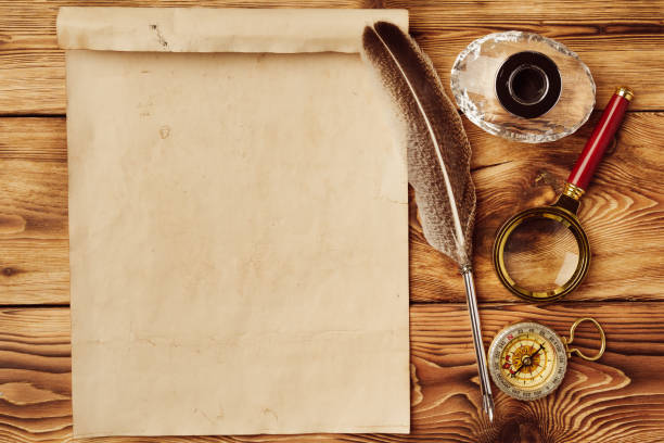 istock Old paper on brown wood background with feather 1522750634
