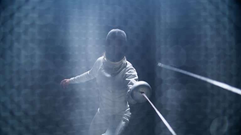 First person POV view two fencers bowing and clashing in combat with foil sabre swords. Landing a direct hit