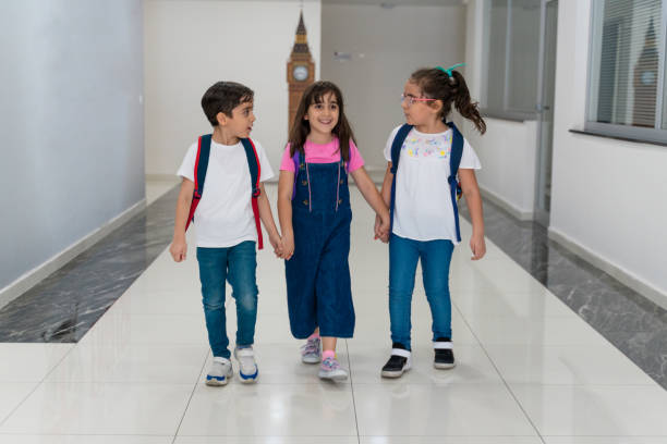istock School kids run holding hands in corridor 1523024230