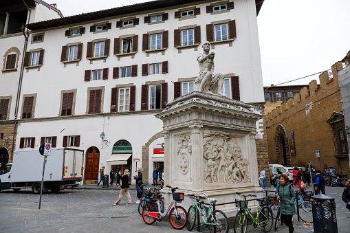 Florence, Italy - April 13, 2023: Monument to Giovanni delle Bande Nere, a marble sculpture by Baccio Bandinelli, visible against the background of an old town residential building.