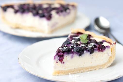 plates with berry cheesecake on lilac tablecloth