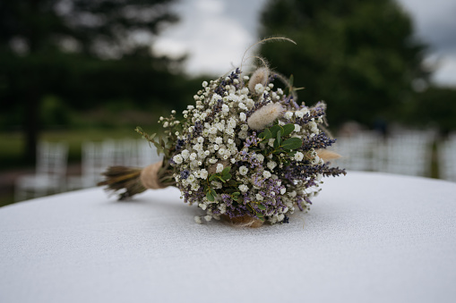 Bridal bouquet lying on table with white color. Preparing for wedding ceremony.