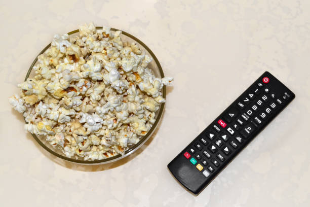 istock there is a plate with popcorn and a TV remote on the table 1523150876