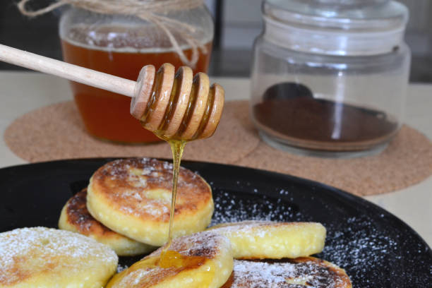 istock honey is poured from a stick onto cheese pancakes 1523206734