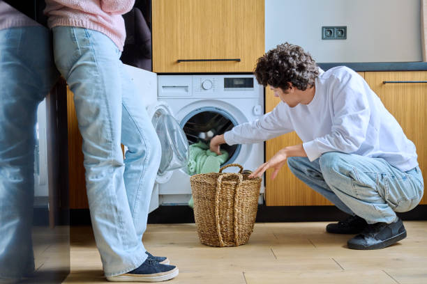 istock Young guy at home using washing machine with basket of dirty things 1523242956