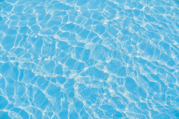 istock Defocused blurred transparent blue colored clear calm water surface texture with ripple. Shining blue water background. 1523278218