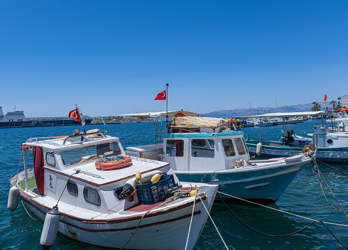 Typical white painted Japanese fishing boat moored at the cove port sea surface.