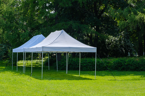 White tents for guests in the park. Party in nature