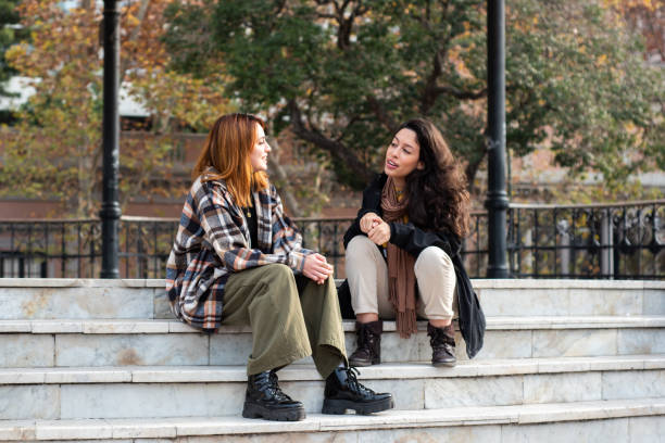 istock Young friends talking sitting on public park stairs 1523374168