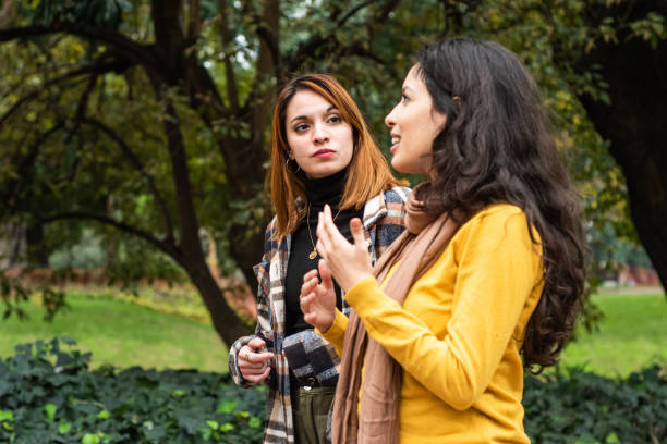 istock Young friends talking while walk through the public park 1523375769