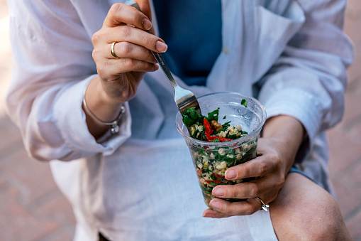 woman eating healthy food salad, focus on salad and fork