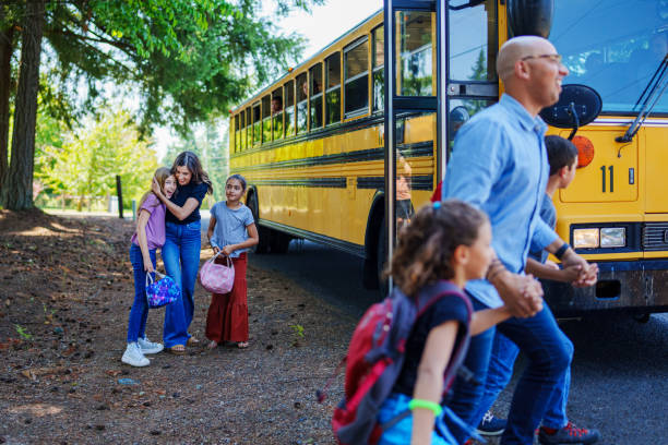 istock Mother greeting her daughters at bus stop after school 1523376967