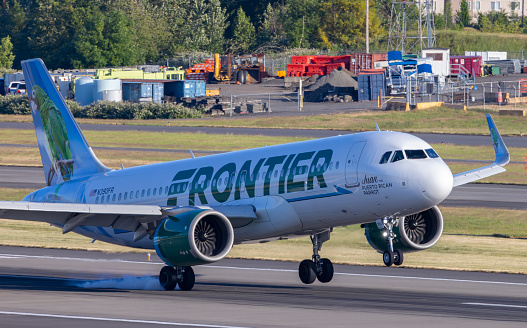 Portland, Oregon, USA - June 10, 2023: A Frontier Airlines Airbus A320 has a bumpy one wheel landing at Portland International Airport.