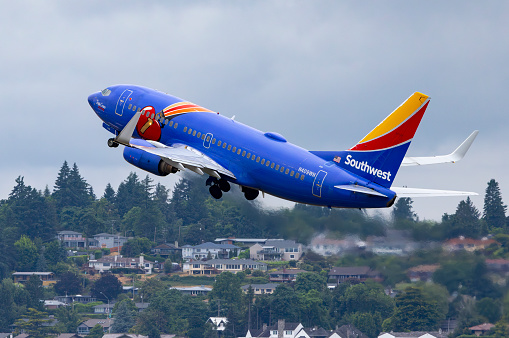 Portland, Oregon, USA - June 8, 2023: The Southwest Airlines Triple Crown livery 737 takes off from Portland International Airport with Vancouver WA in the background.