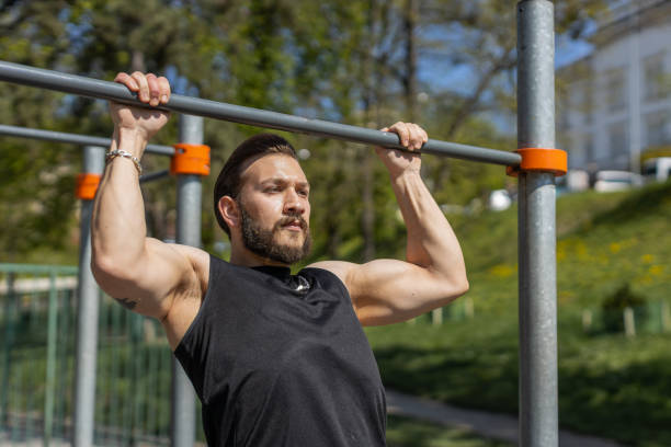 istock Athletic lebanese man in sportswear doing pull ups exercises on horizontal bar, pumping up back 1523652899