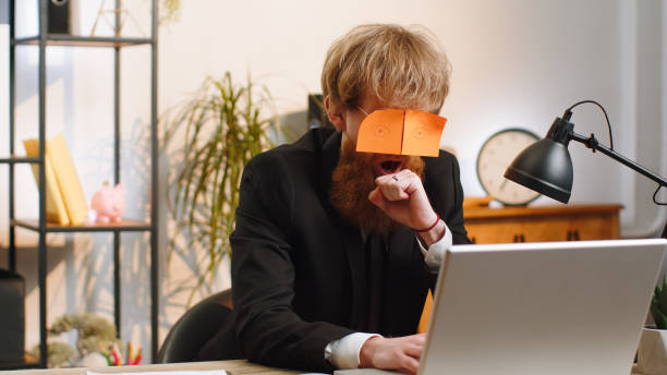 istock Inefficient tired lazy business man working sleeping on laptop computer with eyes stickers on face 1523674956