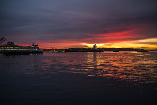 Seattle, USA - Nov 23, 2022: Sunset over Elliott bay as the Hamburg Sud tanker passes.
