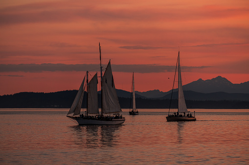 Seattle, USA - Jun 26, 2023: Sunset over Elliott Bay on the waterfront with the Seattle Tall Sailing Ship The Bay Lady.