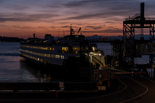 Seattle, USA - Mar 16, 2023: Elliott Bay late in the day as a Ferry disembarks and embarks commuters the Colman dock at Sunset.