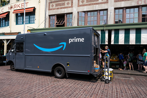 Seattle, USA - May 17, 2023: Mid -day Amazon prime delivery truck delivering to Pike Place Market.