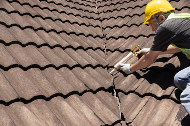 istock Worker man using silicone sealant adhesive  to fix crack of the old tile roof. 1523889529