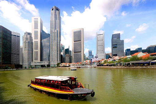 Bumboats provide tours of the Singapore River past the high rise tower blocks of the financial district.