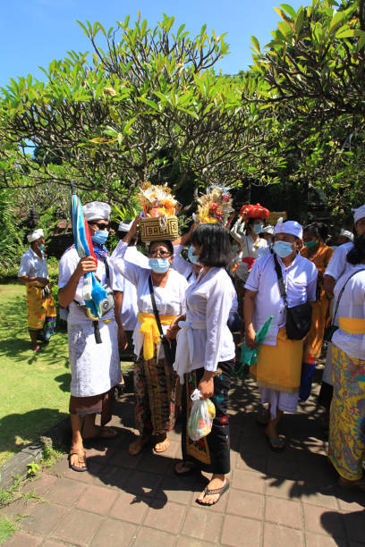 cérémonie balinaise au temple pura goa lawah ou goa lawah dans l’est de bali avec des gens portant des vêtements traditionnels, kebaya, batik sarongs et portant des offrandes sur la tête et avec des hommes portant des chapeaux udeng. - pura goa lawah photos et images de collection