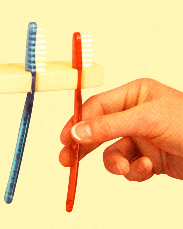 Hand and Two Toothbrushes