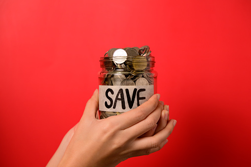 Hand holding coins in glass jar, Financial business investment, Growing money, People saving money, Money for future, Money saving concept. High quality photo