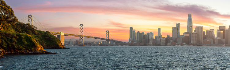 Cityscape view of San Francisco and the Bay Bridge with Colorful Sunset from island, California, USA