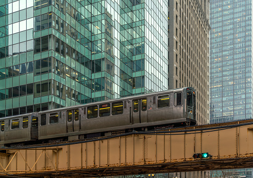 Train on elevated tracks within buildings at the Loop, Glass and Steel bridge between buildings, Chicago City Center, Chicago, Illinois, USA