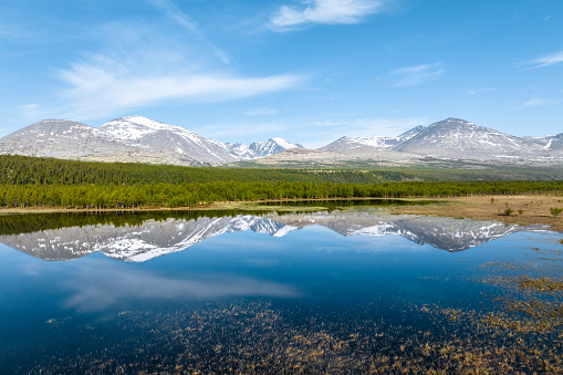 Mountain landscape with a reflection on a calm lake in Rondane National Park, Norway
