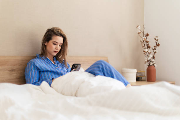 istock Young woman lying on a bed and scrolling her smartphone. 1524480749