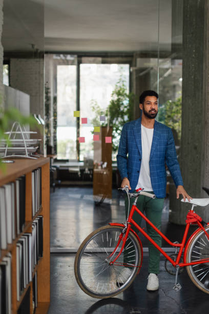 istock Young multiracial man with bicyckle in office. 1524498575