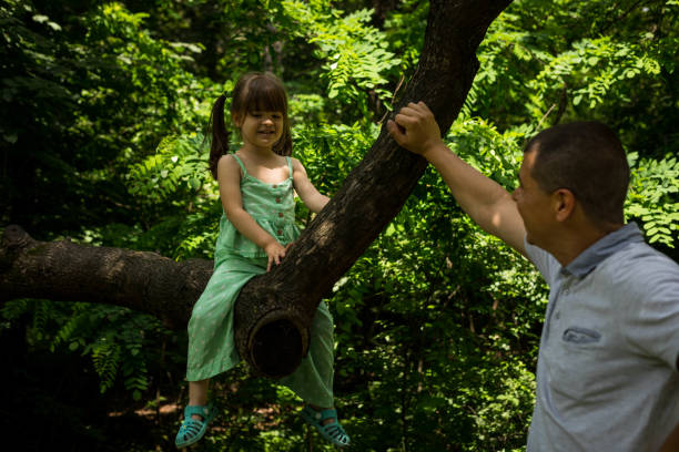 istock A father looks at his child playing in a tree. 1524556543