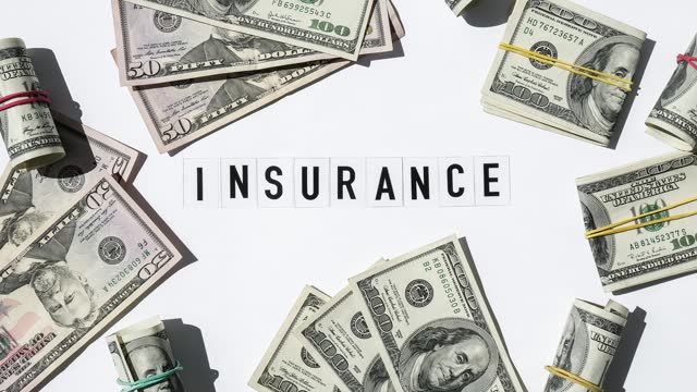 4k zoom in out Text INSURANCE around US dollar banknotes. Health, life, home, car Insurance. Insurance business concept. Health care or medicare insurance and vaccination costs. Financial crisis. Covid-19 crimes