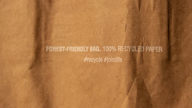4k zoom in out Forest friendly bag Brown paper bag that is 100 recyclable and reusable spbd. Printed plea for user to recycle and reuse this bag as a form of packaging. Symbol indicates paper and cardboard. Concept: ecology