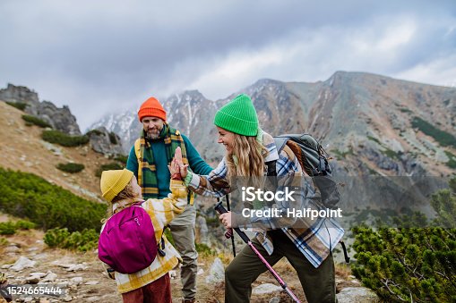 istock Happy family hiking together in autumn mountains. 1524665444