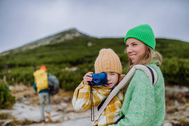 Little girl taking pictures during a hike. Little girl taking pictures during a hike. Happy family hiking together in an autumn mountains. high tatras stock pictures, royalty-free photos & images