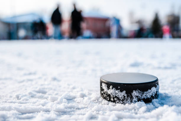 disco de hóquei está na macro neve - ice hockey hockey puck playing shooting at goal - fotografias e filmes do acervo