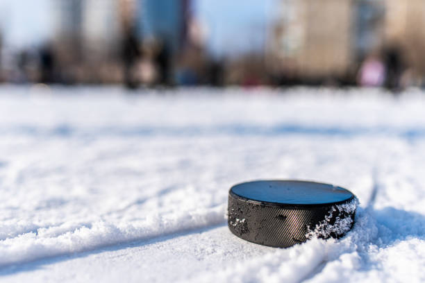 disco de hóquei está na macro neve - ice hockey hockey puck playing shooting at goal - fotografias e filmes do acervo