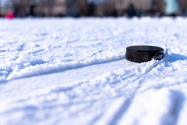 hockey puck lies on the snow macro - ice hockey hockey puck playing shooting at goal imagens e fotografias de stock