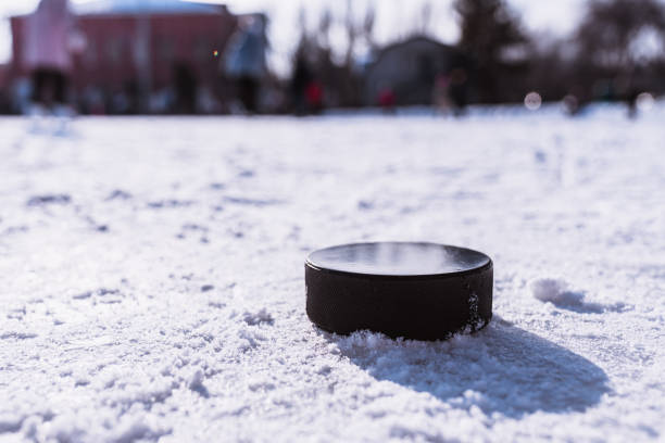 hockey puck lies on the snow macro - ice hockey hockey puck playing shooting at goal imagens e fotografias de stock
